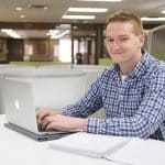 male business student using laptop