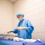 Surgical Technologist in the OP organizing a table of surgical instruments.