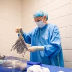 Surgical Technologist in the OP organizing a table of surgical instruments.